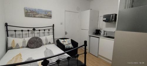 a small bedroom with a bed and a kitchen at Blue Palms in Bournemouth