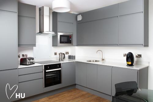 a kitchen with white cabinets and a black appliance at Boutique 1 Bdrm Duplex Suite on Marina-301 in Hull
