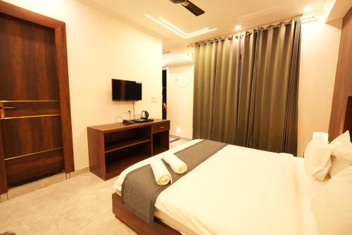 a hotel room with a bed and a television at Hotel Tapovan Hills in Rishīkesh
