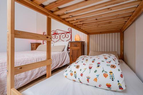 a bedroom with two bunk beds and a wooden ceiling at La Casina Bianca - Discover Umbria in Bastia Umbra