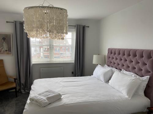 a bedroom with a large white bed with a chandelier at Boutique 1 Bdrm Duplex Suite on Marina-301 in Hull