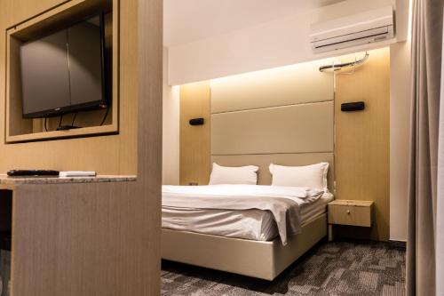 a bedroom with a bed with a tv on the wall at Michid 2 Hotel in Ulaanbaatar