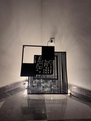 a black bench sitting in a room at Dar D'art Luz Galerie Boutique Guest house in Ghazoua