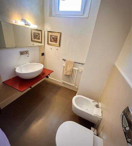 a bathroom with a white sink and a toilet at Art & Lake Apartment in Lecco