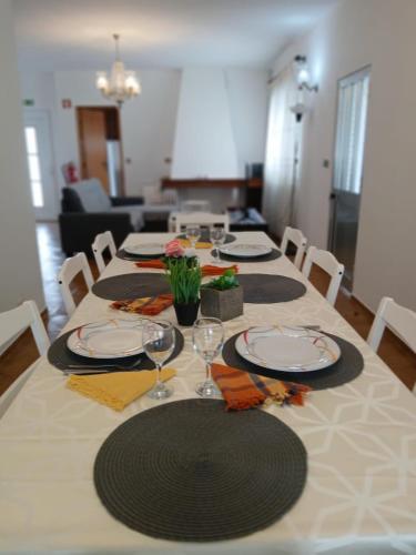 a table with plates and wine glasses on it at Moradia Maria Do Ceu in Vieira de Leiria