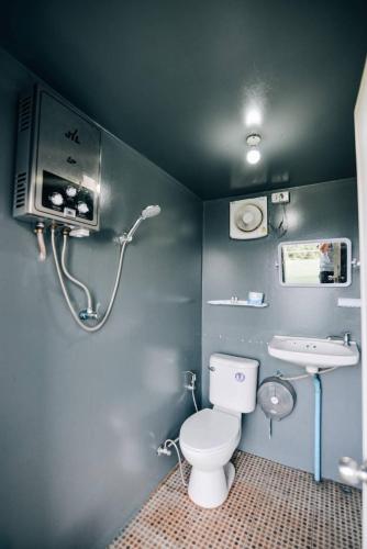 a bathroom with a toilet and a sink at อาฉ่างแคมป์ Achang Camp in Mon Jam