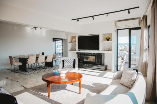 a living room with a couch and a table at Amber View Penthouse 220sqm- overlooking downtown in Limassol