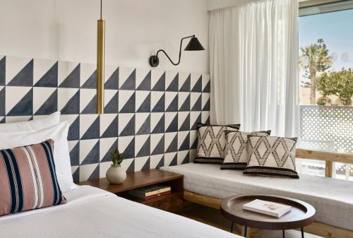 a bedroom with two beds and a striped wall at Phāea Cretan Malia, a Member of Design Hotels in Malia
