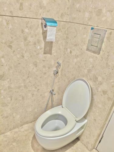 a bathroom with a toilet with a roll of toilet paper at Vilva Town House in Chennai