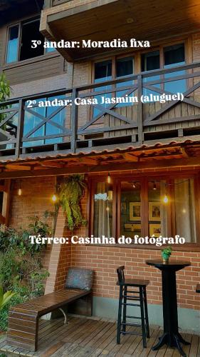 a building with a bench and a table in front of it at Casinha do Fotógrafo em Domingos Martins a 7km do Centro in Domingos Martins