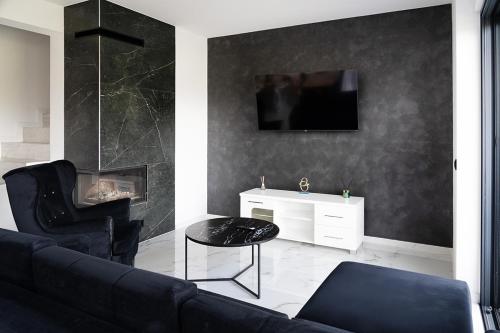 a living room with a couch and a tv on a wall at Apartament 2 z ogródkiem in Sieniawa Żarska