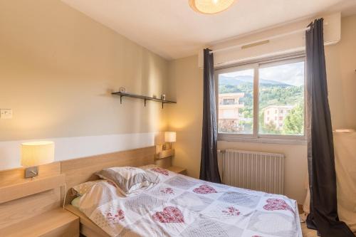 a bedroom with a bed and a window at Le Roc dEmbrun - proche Lac de Serre-Ponçon in Embrun