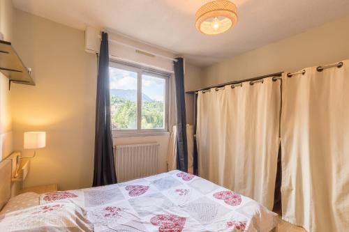 a bedroom with a bed and a window at Le Roc dEmbrun - proche Lac de Serre-Ponçon in Embrun
