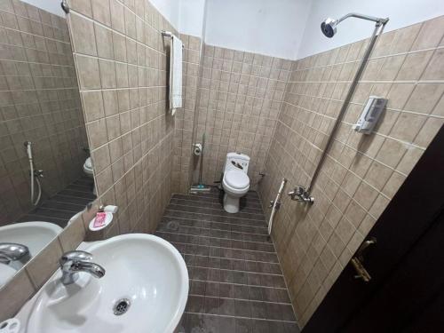 a bathroom with a sink and a toilet at Hotel Grand Pearl in Lahore