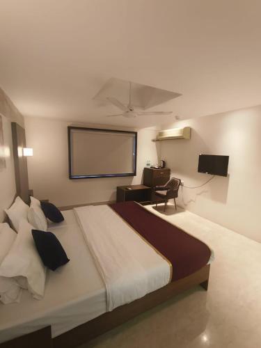 a bedroom with a large bed with a projection screen at Vilva Town House in Chennai