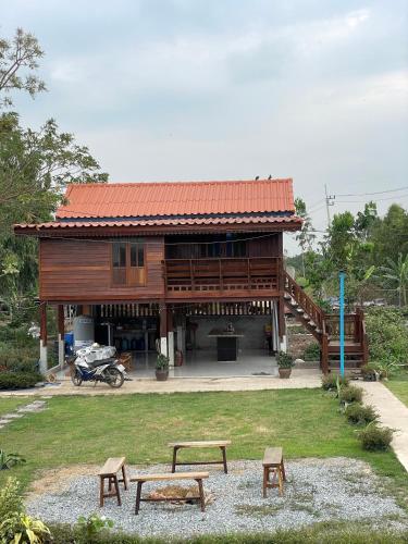 a wooden house with two benches in front of it at BanYat Farm Stay