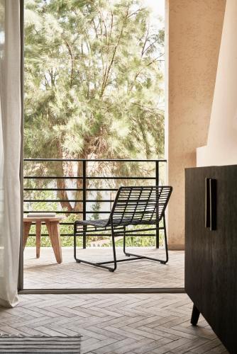 a bench in a room with a large window at Phāea Cretan Malia, a Member of Design Hotels in Malia