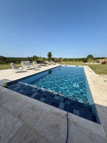 une piscine avec des carreaux bleus et noirs dessus dans l'établissement TheFrenchMill, à Saint-Vivien-de-Monségur