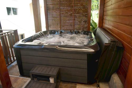 a jacuzzi tub in a room with a bench at O'Meublés des 2Bois- Le Filao-Piscine chauffée & Spa in Le Tampon