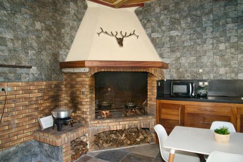 a living room with a brick fireplace with a stove at O'Meublés des 2Bois- Le Filao-Piscine chauffée & Spa in Le Tampon