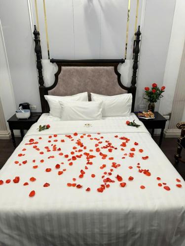 a bed with a bunch of red flowers on it at Khách sạn Đặng Anh in Hanoi