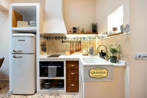 a small kitchen with a sink and a refrigerator at Mi Andalusia Hotel Experience in Málaga