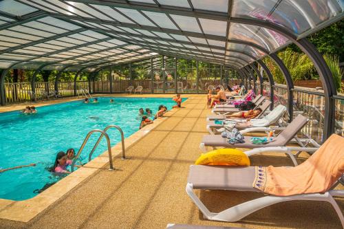 a swimming pool with a bunch of people in the water at Camping Hourtin in Hourtin