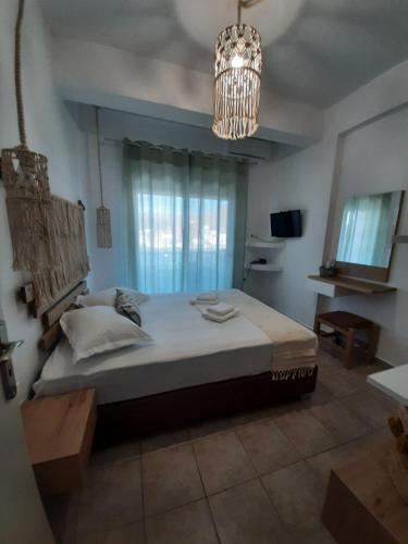 a bedroom with a large bed and a chandelier at Romantza δωμάτιο 4 in Mérikhas