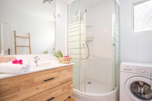 a bathroom with a sink and a washing machine at Coconut Bay House avec Piscine et Jacuzzi in Le Robert