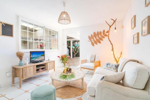 a living room with a couch and a tv at Coconut Bay House avec Piscine et Jacuzzi in Le Robert