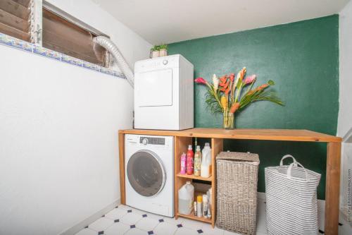 a laundry room with a washing machine on a shelf at Coconut Bay House avec Piscine et Jacuzzi in Le Robert