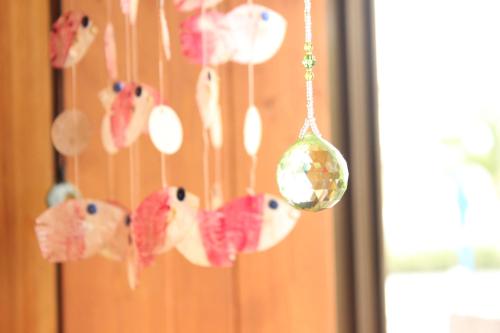 a group of fish ornaments hanging from a wall at Katsuo Guest House in Kochi