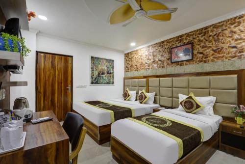 una camera d'albergo con due letti e una scrivania di Hotel Smart Lax a Nuova Delhi