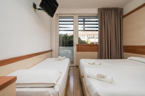 a hotel room with two beds and a window at Hotel Centro Turistico Gardesano in Bussolengo