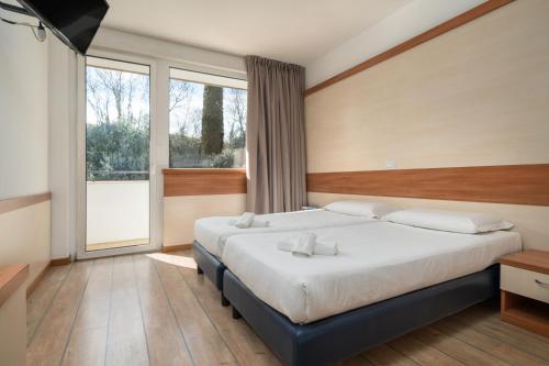 a bedroom with a large bed and a large window at Hotel Centro Turistico Gardesano in Bussolengo