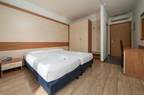 a bedroom with a large bed and a wooden floor at Hotel Centro Turistico Gardesano in Bussolengo