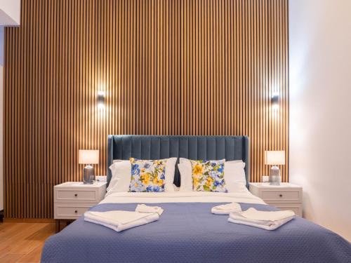 a bedroom with a blue bed with two night stands at Villa Luma With Heated Pool, Jacuzzi, Gym, Sauna and Cinema Room in Sliema