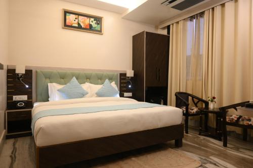 a bedroom with a large bed with blue and white pillows at Hotel Kashi Crown in Varanasi