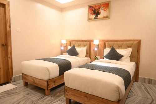 two beds in a hotel room with at Hotel Kashi Crown in Varanasi