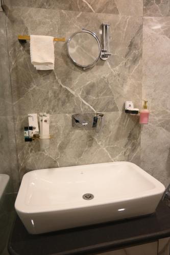a bathroom with a white sink and a mirror at Hotel Kashi Crown in Varanasi