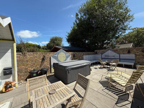 a patio with a grill and chairs and a table at Broadstairs Apartments with luxurious 4-person communal hot tub - sleeps up to 20 people in Broadstairs
