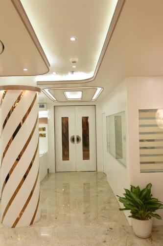 a hallway with white walls and a ceiling at Hotel Kashi Crown in Varanasi