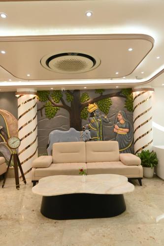 a living room with a couch and a painting on the wall at Hotel Kashi Crown in Varanasi