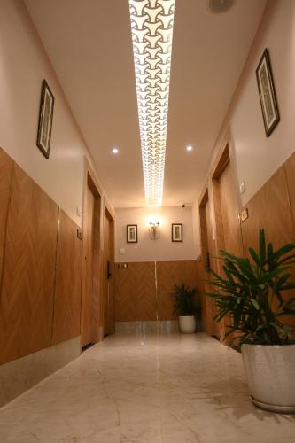 an office hallway with wooden doors and a plant at Hotel Kashi Crown in Varanasi