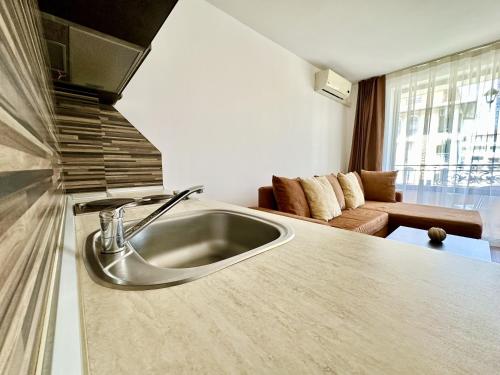 a kitchen with a sink and a living room at Menada Diamant Apartments in Sunny Beach