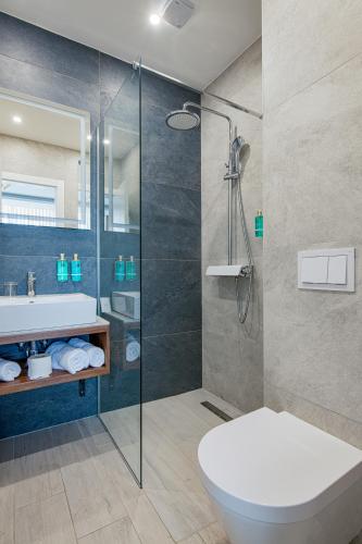 a bathroom with a shower and a toilet and a sink at Heritage Hotel Stypia in Crikvenica