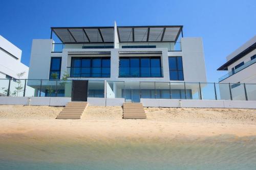 a building on the beach in front of the water at Silk Valley - 4B near Al Hamriyah | private beach access in Sharjah