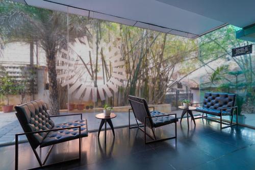 a room with two chairs and a large clock on the wall at Olive Hotel MG Road Dunsvirk Inn by Embassy Group in Bengaluru