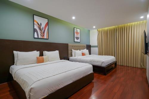 a hotel room with two beds and a television at Olive Hotel MG Road Dunsvirk Inn by Embassy Group in Bengaluru