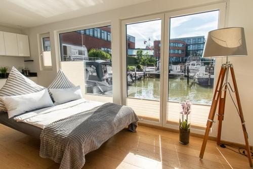 a bedroom with a bed and a view of a marina at ANKERLOFT - Hausboot in Hannover